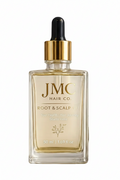 JMC Hair Co. Root & Scalp Oil in a clear glass dropper bottle with a gold collar and black dropper top, displayed on a round stone slab with olive sprigs and seeds against a white background.